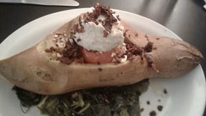 A giant sweet potato with vegan herbed cream cheese, coconut bacon, and collard greens.  It was so yummy! at The Catalyst Cafe in Missoula
