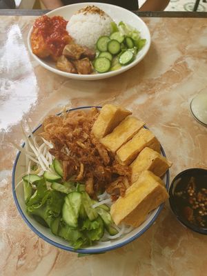 In the back: steamed rice and food, in the front: vietnamese noodles and fried tofu with soya souce at The Garden Cafe & Vegetarian Food in Hue