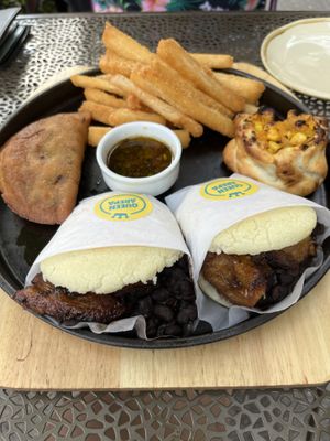Vegan platter with arepas, two types of empanadas, yucca fries, and sauces. Fillings are squash, beans, and plantains.   at Bar Bacan in Toronto