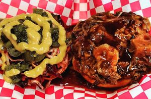 SMOKED BBQ AND BACUN SLAW SAMMICH, our slow smoked bbq in our house bbq sauce topped with our bacun rainbow slaw, onions, pickled jalapenos, bbq, and mad sauce. at Mad Munchies in Pensacola