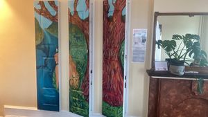 In the upstairs seating area: three little doors with art painted on them at Luhv Vegan Bistro in Philadelphia