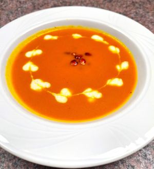 Carrot-ginger-coconut milk soup finished with lentil cream and pomegranate arils for our May Day 2024 event. at Roberto's Pizza in Scranton