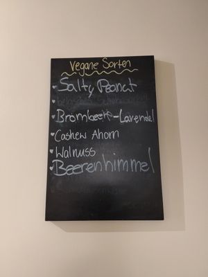 Die aktuellen, veganen Sorten stehen auch auf einer Tafel an der Wand in der Eisdiele at Glacë Manufaktur in Trier