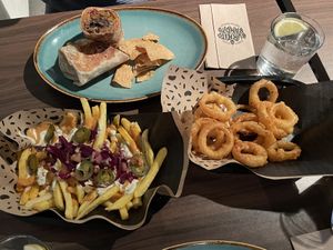 Outlaw burrito (CHF 16.00) with crispy onion rings (CHF 05.00) and vegan loaded fries (CHF 12.00)  at Burrito Bandito in Bern