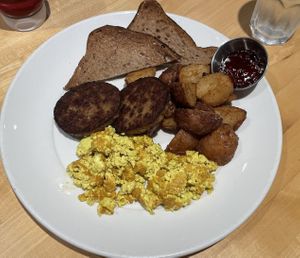 On the menu as “Impossible Eggs”, Pan seared Impossible sausage, Indian spiced tofu scramble, served with crispy potato and gluten free toast.   at Abode in Vancouver