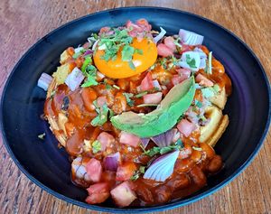 Rancheros: green chili pinto beans, squash, smashed potatoes, enchilada sauce, sunshine sphere (encased carrot juice/sauce served as "yolk", cilantro, tomatoes and red onions, all  at Knead  in Albuquerque