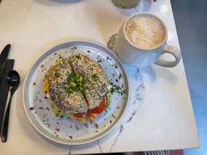 Everything bagel with vegan cream cheese, vegan scrambled egg, vegan bacon bites and tomatoes and a banana bread latte at OH Bagel in Muenster