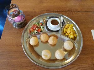 Pani puri as a starter . You have to stuff the hollow balls with the ingredients and the sauce. at Little India in Nijmegen