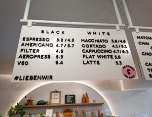 On pink sticker " no extra charge for Oatly" at Café Lieben Wir in Vienna