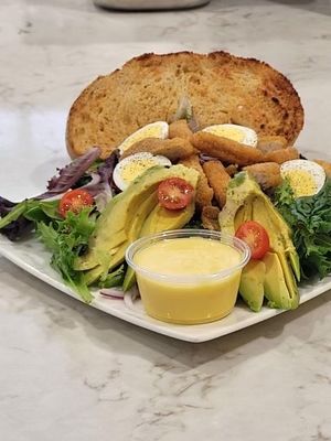 Honey mustard “chicken” sandwich made with impossible brand chicken. (spring mix, cherry tomatoes, red onion, avocado, hard boiled egg, honey mustard dressing) at V Cafe  in Long Beach