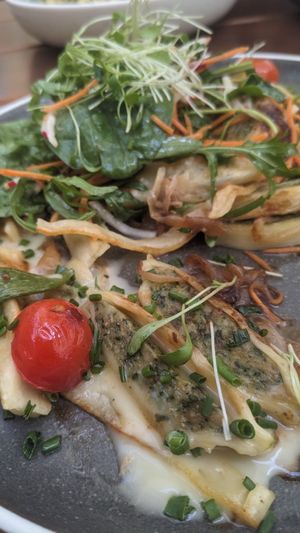 Maultaschen mit geschmelzten Zwiebeln und veganem Käse, obendrauf ein bunter Salat at Virtshaus in Ulm