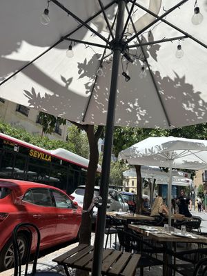 Seating outside with parasols and lights  at Balino Yoga Café  in Sevilla