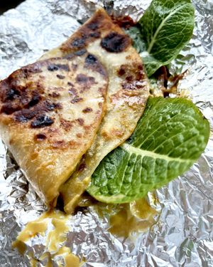 Delivered vegan Sattwich: homemade flatbread stuffed with zucchini, eggplant ragout, baked sweet peppers, roasted crushed beans, pickles, vegan cheese sauce at Aygi in Yerevan