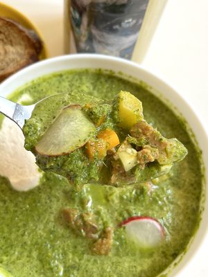 Vegan Okroshka (Russian summer cold soup) with hearty green "broth", homemade sausages, cucumbers, radish, boiled potatoes, boiled carrots, and cashew sauce at Aygi in Yerevan