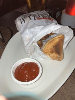 Pizzabrötchen with one piece already being eaten   at Cafe Extrablatt in Sylt