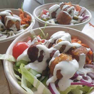 Falafel bowl with homemade lemon garlic tahini, fried eggplant, orange pickled carrot, tomato, cucumber, onion, olives and lettuce at Vegan Pop Up Café in Bergen