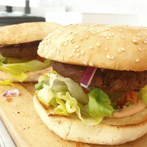 Juicy burgers with homemade dressing, lettuce, tomato, pickles and onion at Vegan Pop Up Café in Bergen