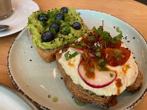 Breakfast toast with smashed avocado-pea-creme and cream cheese with dried tomatos   at Morgentau. in Barcelona