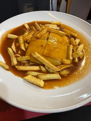 Francescinha vegan is a large meal in a deep bowl with vegetables and sausage and melts cheese on the inside covered in gravy   at Taska Da Su Aqueduto in Evora