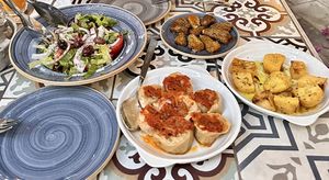 Horiatiki salad, cabbage dolmades, zucchini flower and baked potatoes   at Hamam Cafe in Rhodes