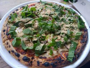 Weekly pizza with broccoli, wild garlic, and cashew parmigiano at NOAH in Mainz