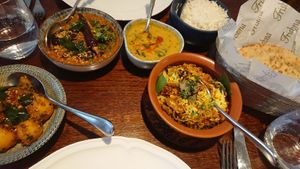 Main courses (mushroom biryani and aubergine) with sides (rice, bread, dal and potatoes) at Trishna in London