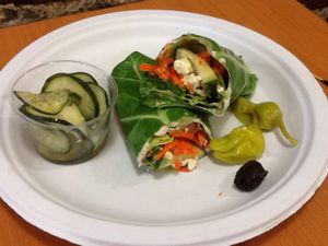 Vegetarian and gluten-free Greek wrap on collard leaf with a raw vegan, gluten-free sweet cucumber salad side. at Superfoods Cafe & Market in Mt Airy