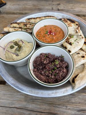 Vegan Muhammara, hummus, and black olive tapenade with delicious grilled bread.  at Bar Neon in Toronto