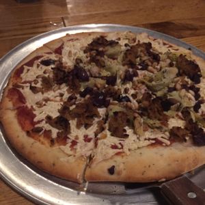 gluten free, vegan cheese, vegan Italian sausage, pine nuts, & artichokes pizza at The Mitten Brewing Co in Grand Rapids