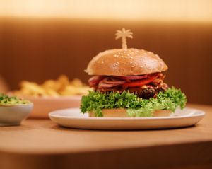 Delicious Peanutbutter Bacon Burger mit fluffigen Brioche Bun, belegt mit unserem saftigen Hulala-Patty, würziger Burgersauce, Salat, Tomaten, Zwiebeln, veganem Bacon, ergänzt durch Peanutsauce und Erdnüsse. 🍔🤙🌴 at Hulala in Dusseldorf