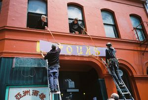 Hoisting the sign at Yours in Dunedin