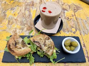 Focaccia with hummus, artichoke, rocket and carob protein shake   at MegaRawBar in Mallorca