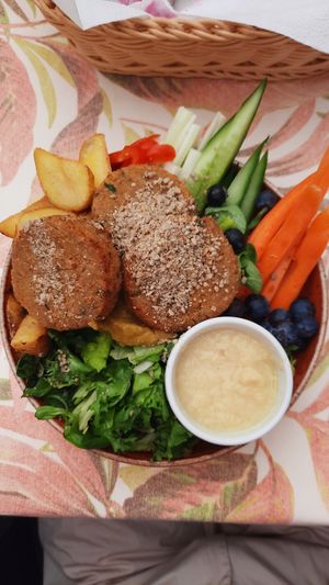 Buddha bowl with veggie patties, potatoes, different kinds of lettuce, selery, cucumber, carrots, bell pepper, blueberries, olives, vinaigrette dressing, honey mustard sauce at Carmen in Miedzyzdroje