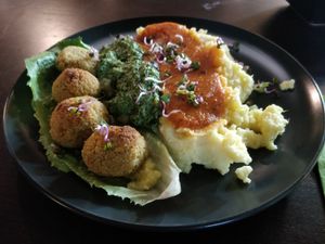 Main course: smashed potatoes and couscous "meat" balls with tomato sauce and pesto at Nom Nom in Bucharest