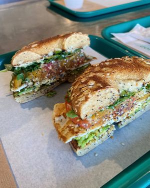 Our vegan Pacific Bagel Sandwich: (this photo has a farm fresh egg added) hummus, fresh avocado, heirloom tomato & arugula w/ our lemon vinaigrette on a toasted multigrain bagel at Whale Bites Cafe in Depoe Bay