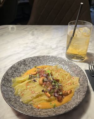 Steamed leeks on harissa cream topped with a green apple vinaigrette and roasted cashews.  at La Huerta Funky Castizo in Madrid