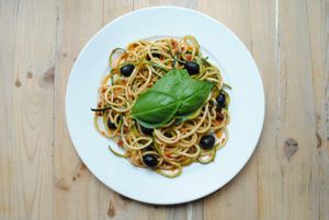 ZUCCHINI PASTA. Raw spaghetti with pesto of dried tomatoes and sunflower. Served with rucola, black olives and fresh basilicum. at Vega in Wroclaw