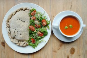 Tomato soup with basil and pizza calzone with vegetable and vegan cheese.  at Vega in Wroclaw