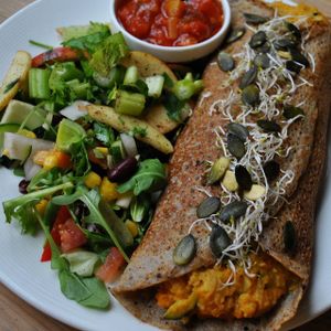 Buckwheat pancake with pumpkin-zucchini filling, coriander, cumin, tomato dip and fresh salad. at Vega in Wroclaw