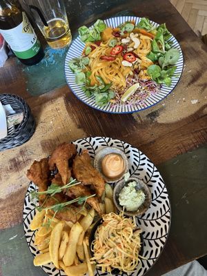 Top plate: pad thai with tofu and mango, bottom plate: fried oyster mushrooms with salad and fries .  at Vega in Wroclaw