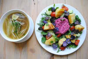 Broth made by roasted vegetables with 'soba' pasta and salad with spinach, rocket, tomato and roasted potatoes with beetroot tzatziki sauce. at Vega in Wroclaw