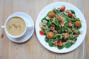 Pear-ginger soup with rice noodles, salads with spinach and rocket, tofuballs, almond-orange pesto, tahini dressing with tomatoes and sunflower seeds. at Vega in Wroclaw