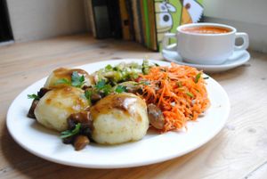 Dumplings stuffing with lentils and chickpea with mushroom sauce and salads. at Vega in Wroclaw