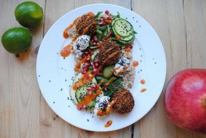 Pearl barley with fresh spinach, zucchini, cucumber and lime juice, pomegranate, yogurt-mint sauce, banana ketchup and falafels. at Vega in Wroclaw