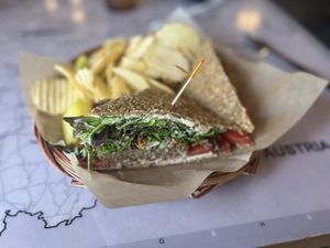 Athena’s Gift- Raw, gluten-free vegan sausage topped with cashew cheeze spread, spring mix, olive salad, and tomatoes. Served with chips and a pickle spear    at European Street in Jacksonville