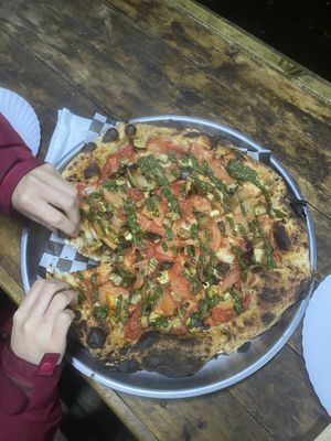 Vegan #1 pizza, family size, with hungry hands  at La Cova Pizzería in Pucon