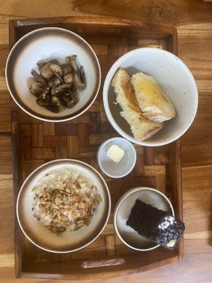 Breakfast with sourdough, Sautéed mushrooms, Muesli with oat milk, and vegan chocolate cake - served with none vegan butter    at Mimamori in 