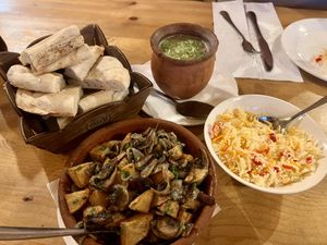 Rice, beans in a clay pot, mushrooms with potatoes, and Georgian bread  at Restaurant Cozy Corner Kazbegi  in Stepantsminda