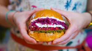 Bun with sesame seeds, beetroot patty, vegan feta sauce, sweet and sour onion, walnuts pest at Green M'ama in Naples