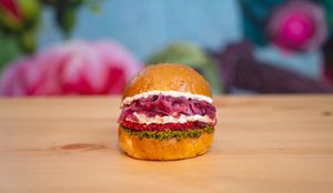 Bun with sesame seeds, beetroot patty, vegan feta sauce, sweet and sour onion, walnuts pest at Green M'ama in Naples